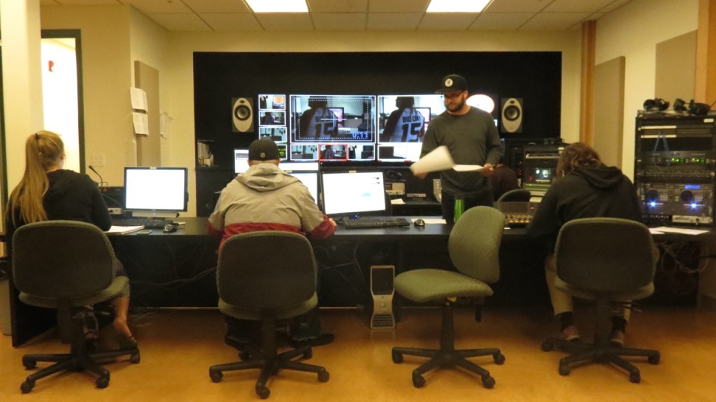 photo of j-school broadcast students working on video production on their screens.