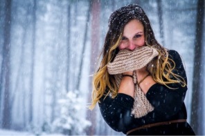 A self portrait of Felstet clutching a scarf to her face while standing in the snow