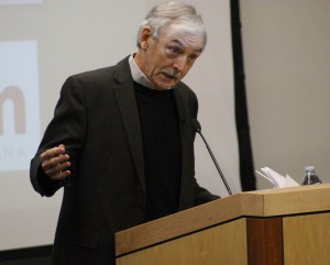 Ken Wells speaks to a crowded room