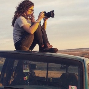 Bronte Wittpenn sits atop her car preparing to take a picture.