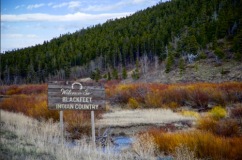 Landscape photo with a sign in the foreground that reads "Welcome to Blackfeet Indian Country."