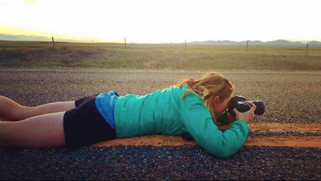 Native News photographer Sophie Tsairis lays in the middle of a deserted highway to snap a photo of the landscape.